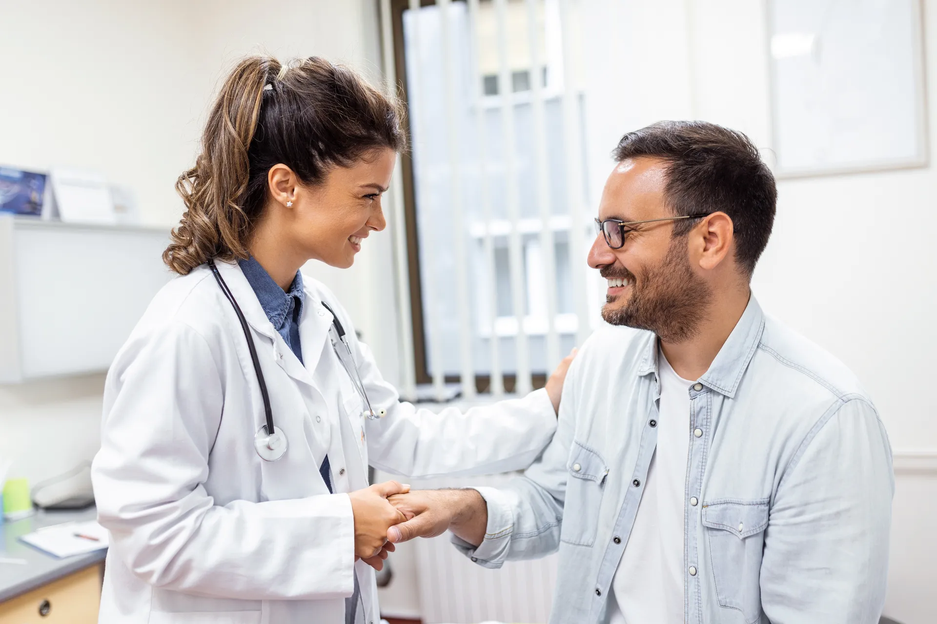 A clinician speaking with a patient in a consultation room