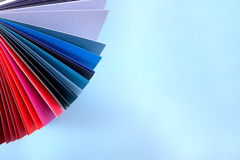A fan of colored file folders on a pale surface