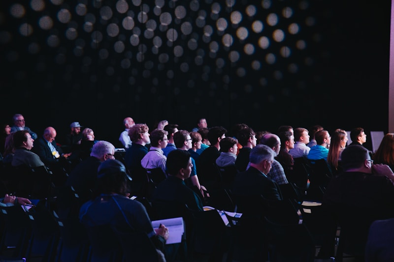 People seated in a public audience during a presentation